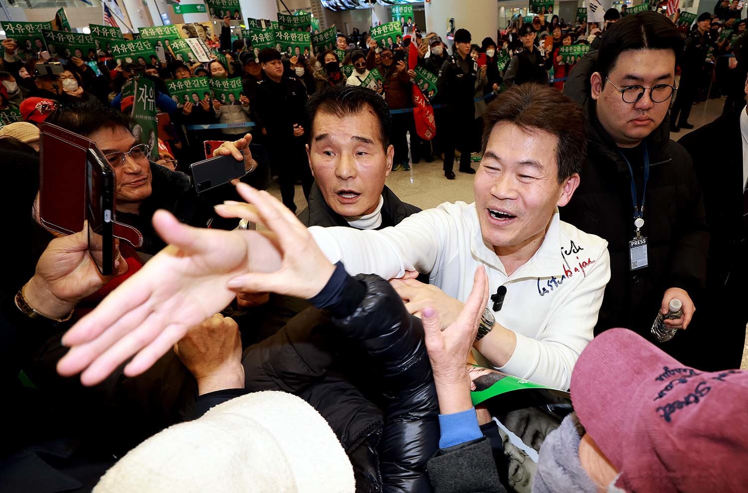 전한길 씨가 3일 인천국제공항 제2여객터미널로 귀국해 지지자들을 향해 손을 뻗고 있다. / 뉴스1