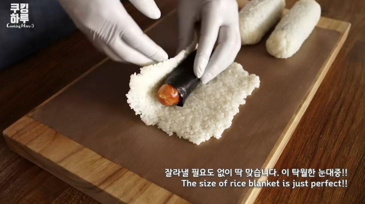 펼친 밥에 김으로 감싼 소시지를 마는 모습. / 유튜브 '쿠킹하루 Cooking Haru :)'