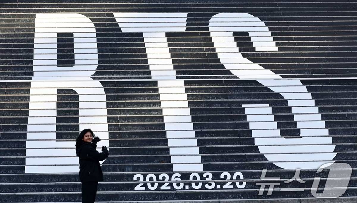 지난달 22일 오후 서울 종로구 세종문화회관 계단에 설치된 방탄소년단(BTS)의 정규 5집 컴백을 알리는 홍보물을 배경으로 관광객들이 기념촬영을 하고 있다 / 뉴스1