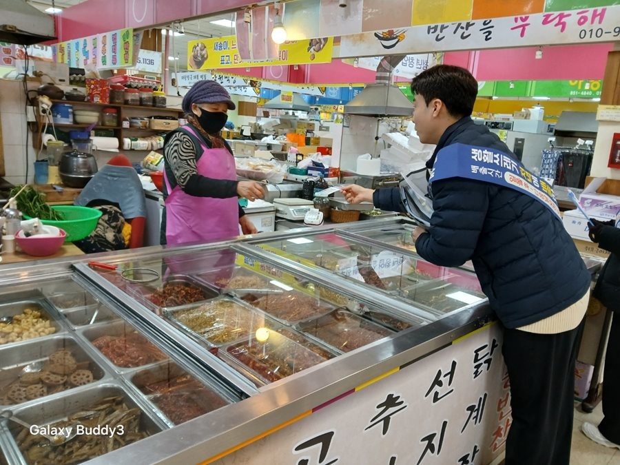경산시 단속 요원이 전통시장을 찾아 상인을 대상으로 생활쓰레기 분리배출 홍보 활동을 하고 있다. / 경산시 제공