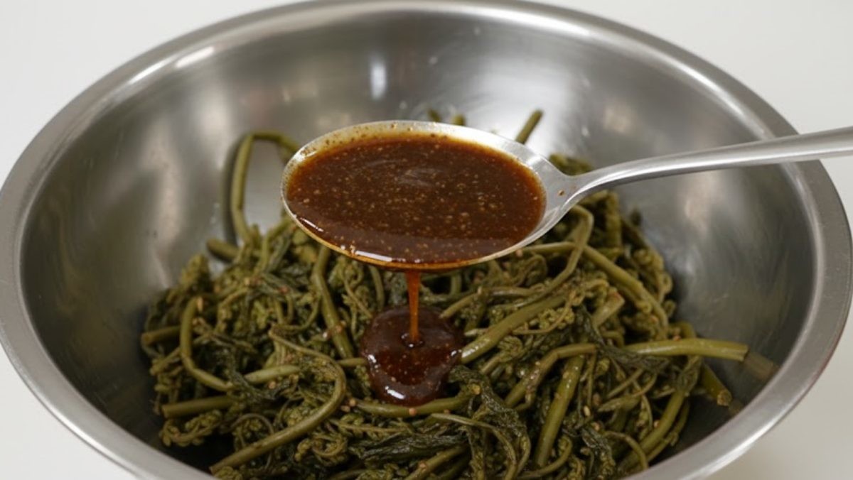 고사리에 '만능 양념장'을 넣는 모습. 기사 내용을 바탕으로 AI가 생성한 자료사진. (실제와 차이가 있을 수 있음을 밝힙니다.)