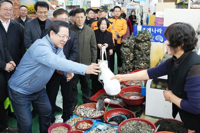 김영록 전라남도지사가 설 명절을 앞둔 13일 지역 전통시장인 광양 중마시장을 방문, 물품을 구매하며 상인들을 격려하고 있다.