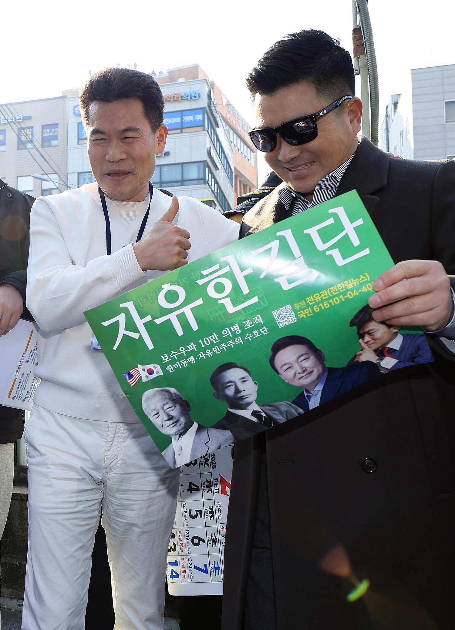 이재명 대통령과 김현지 청와대제1부속실장에 대한 허위 사실을 유포한 혐의로 고발된 한국사 강사 출신 보수 유튜버 전한길 씨가 12일 오전 서울시 동작구 노량진역 앞에서 피의자 신분 경찰 첫 소환 조사 출석에 앞서 기자회견을 하고 있다. 전 씨 옆에 있는 선글라스를 쓴 남성이 김현태 전 707특수임무단장으로 확인됐다. / 뉴스1