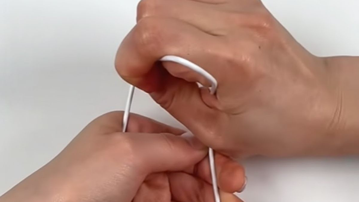 옷걸이 끝을 눌러 접는 모습. 유튜브 채널 '짧지식' 영상 속 장면을 AI로 재생성한 이미지. / 유튜브 '짧지식'