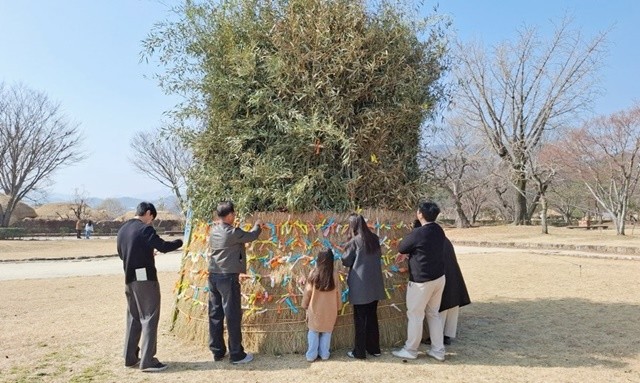 순천 낙안읍성 내 설치된 달집에 관광객들이 소원지를 달고 있다