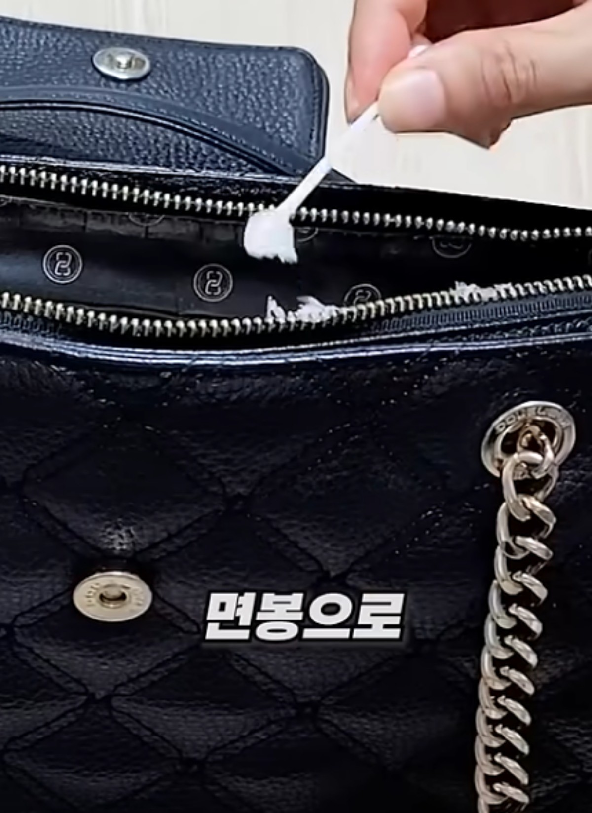 면봉으로 지퍼에 바세린을 바르는 모습 / 유튜브 '진짜꿀팁'