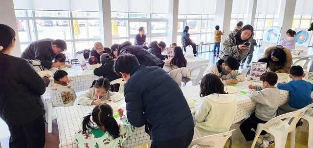 순천만잡월드를 찾은 가족 단위 관람객들이 ‘붉은 말’ 키링 만들기 체험에 참여하고 있다