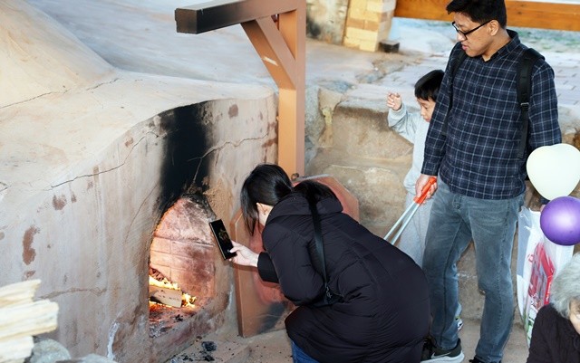 제54회 강진청자축제장은 찾은 한 가족이 화목가마에서 불을 지피며 가족의 안녕을 기원하고 있다.