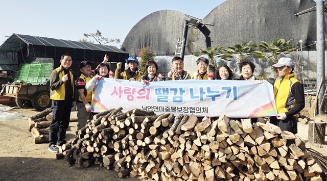 순천시 낙안면마중물보장협의체 위원들이 사랑의 땔감 나누기 행사를 갖고 기념촬영을 하고 있다