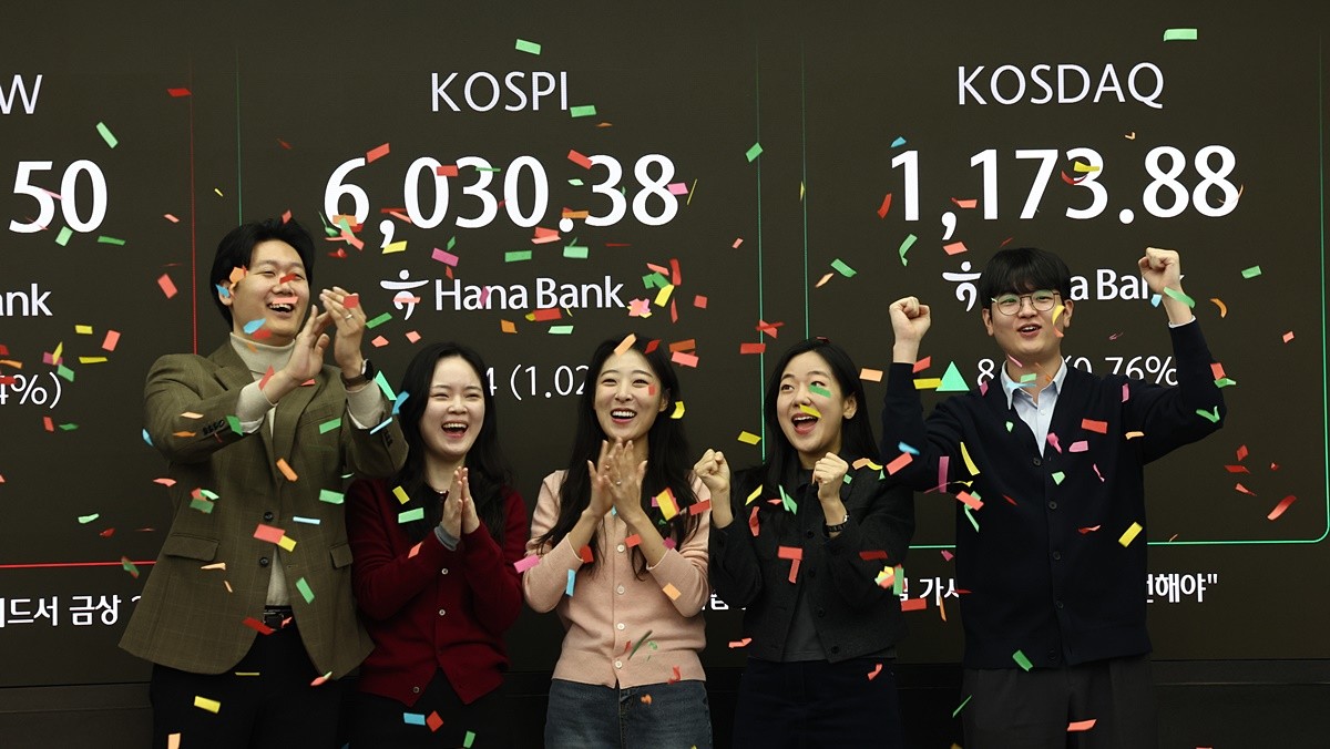 코스피 지수가 장 시작과 함께 6000포인트를 돌파한 25일 오전 서울 중구 하나은행 본점 딜링룸 전광판에 증시 시황이 표시되어 있다. 직원들이 6000포인트 돌파를 축하하고 있는 모습 / 뉴스1