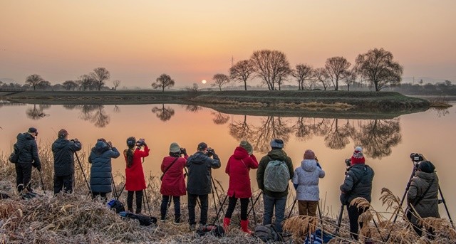 남도풍경연구소 소속 사진작가들이 동섬에서 떠오르는 해를 촬영하고 있다.