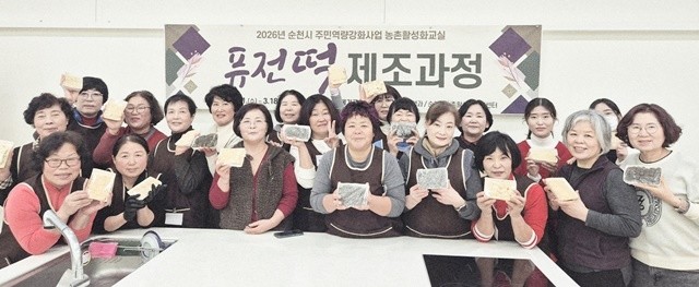 순천시 주민역량강화 사업으로 운영된 농촌활성화교실 퓨전떡 제조과정에 참여한 주민들이 기념 촬영을 하고 있다.