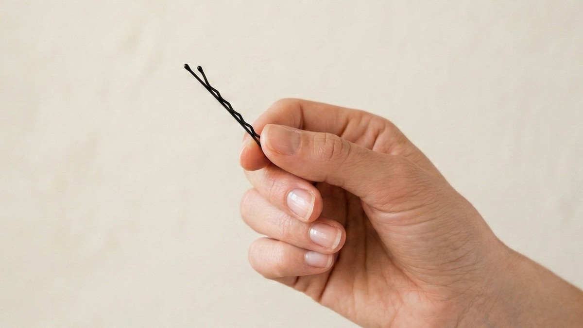 기사를 바탕으로 AI가 생성한 자료사진. 실핀을 보면 한쪽은 물결처럼 굴곡이 있고, 다른 한쪽은 매끈하다. 이때, 굴곡이 있는 면이 안쪽이 되도록 꽂아야 머리카락 흘러내림을 줄일 수 있다.