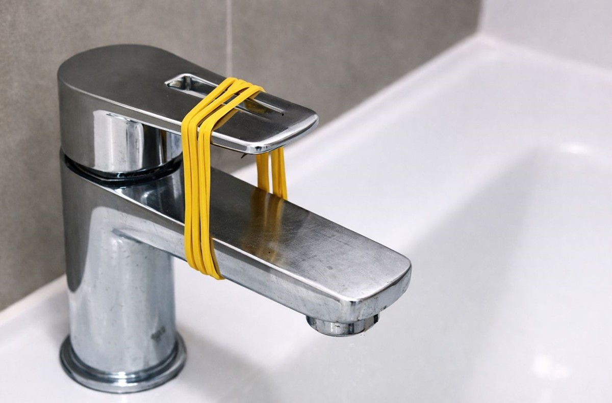 고무줄로 세면대 수도꼭지를 묶은 모습. 기사 이해를 돕기 위해 AI를 활용해 제작한 자료 사진입니다. 실제 모습과 다소 차이가 있을 수 있습니다.