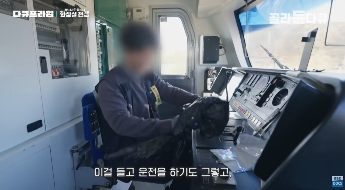 달리는 열차 안에서 대변을 담은 비닐을 밀봉하는 기관사. / 유튜브 채널 'EBS 다큐'