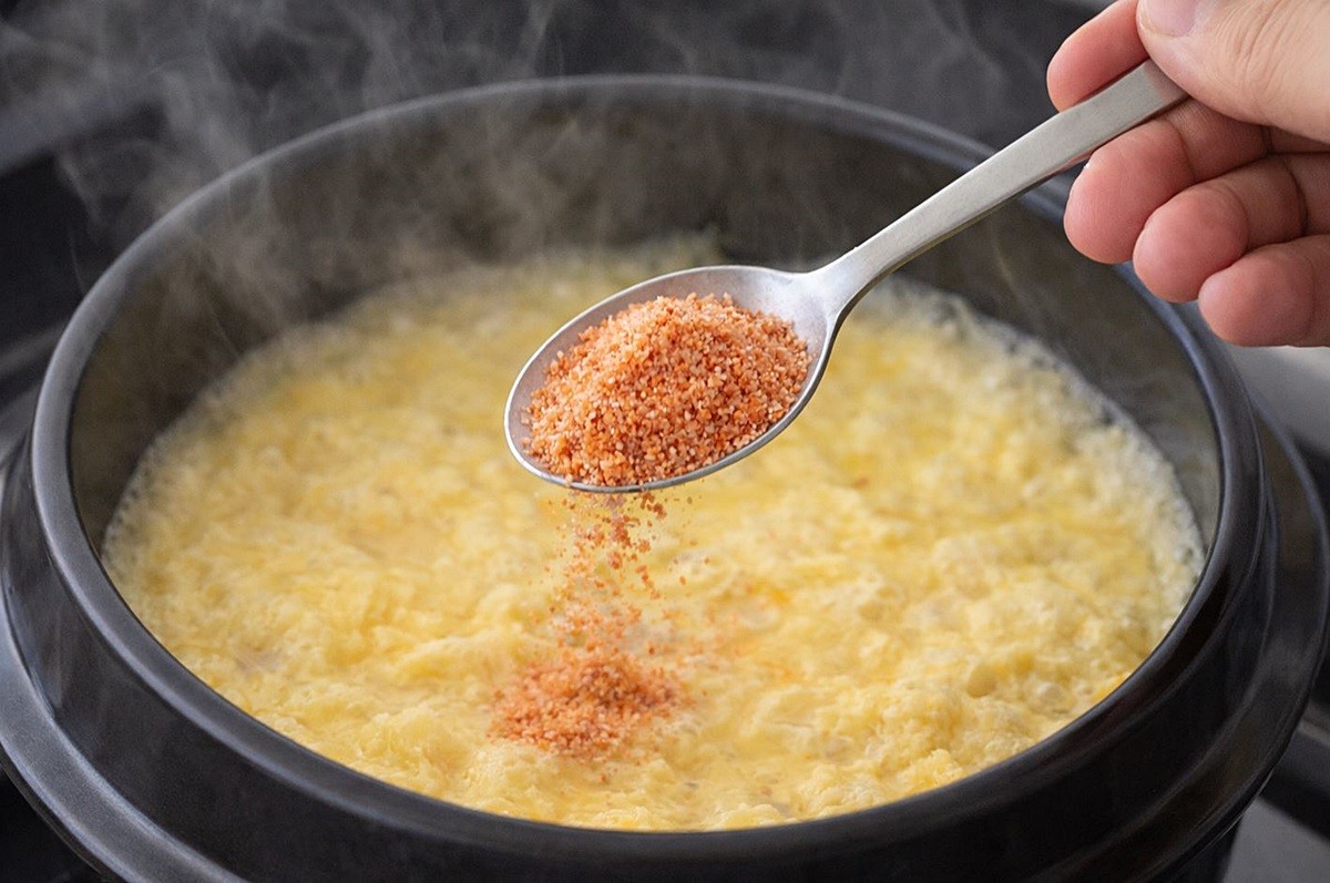 계란찜을 만들 때 새우가루를 넣는 모습. 기사 이해를 돕기 위해 AI를 활용해 제작한 자료 사진입니다. 실제 모습과 다소 차이가 있을 수 있습니다.