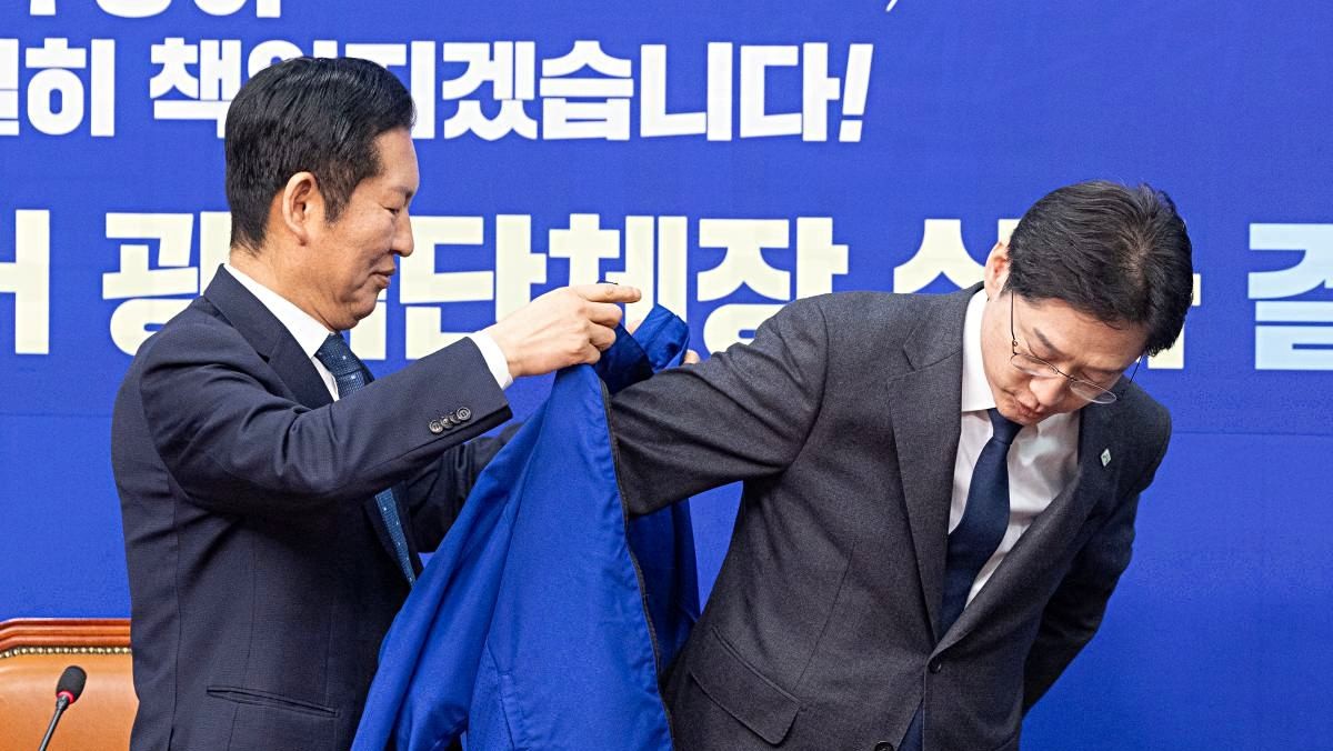 5일 서울 여의도 국회에서 열린 더불어민주당 공천 심사 결과 발표에서 정청래 대표가 경남지사 후보로 단수 공천된 김경수 지방시대위원장에게 점퍼를 입혀주고 있다. 더불어민주당은 6·3 지방선거 '3호 단수공천'으로 김경수 대통령 직속 지방시대위원회 위원장을 경남지사 후보로 선정했다.  / 뉴스1