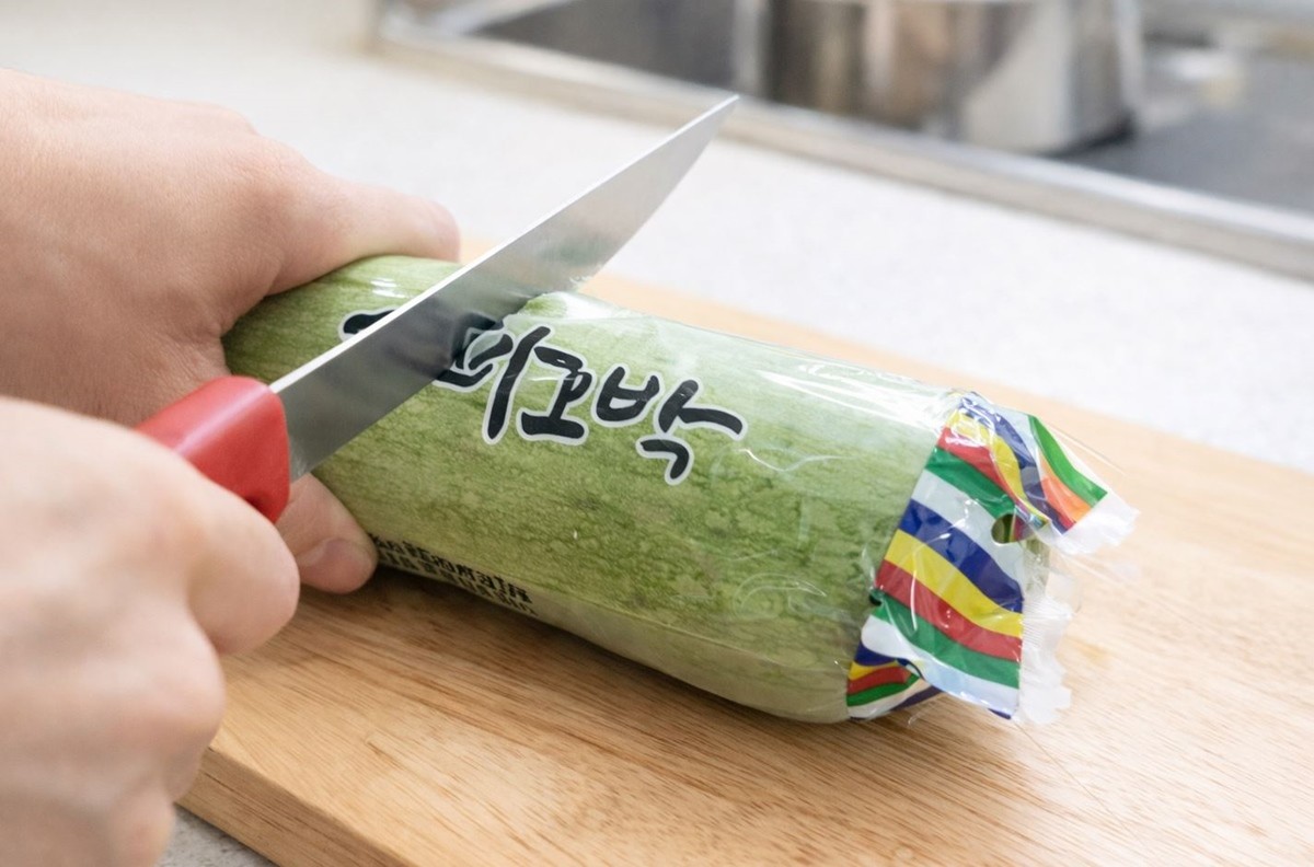 애호박 포장 비닐을 칼로 자르는 모습. 기사 이해를 돕기 위해 AI를 활용해 제작한 자료 사진입니다. 실제 모습과 다소 차이가 있을 수 있습니다.