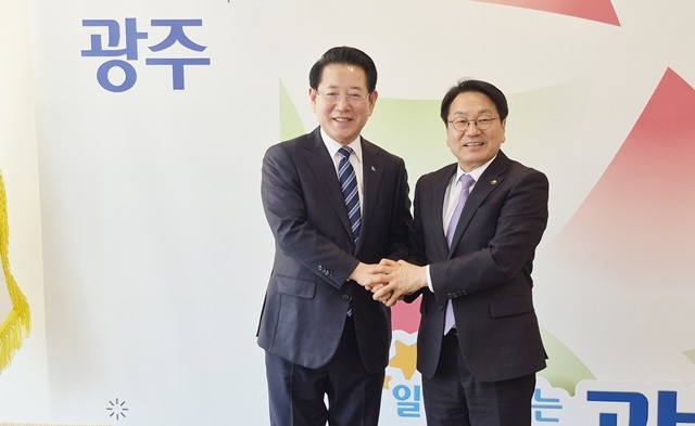 김영록 민주당 전남광주특별시장 예비후보(왼쪽)와 강기정 광주광역시장인 13일 광주시청에서 환담하고 악수를 하고 있다.