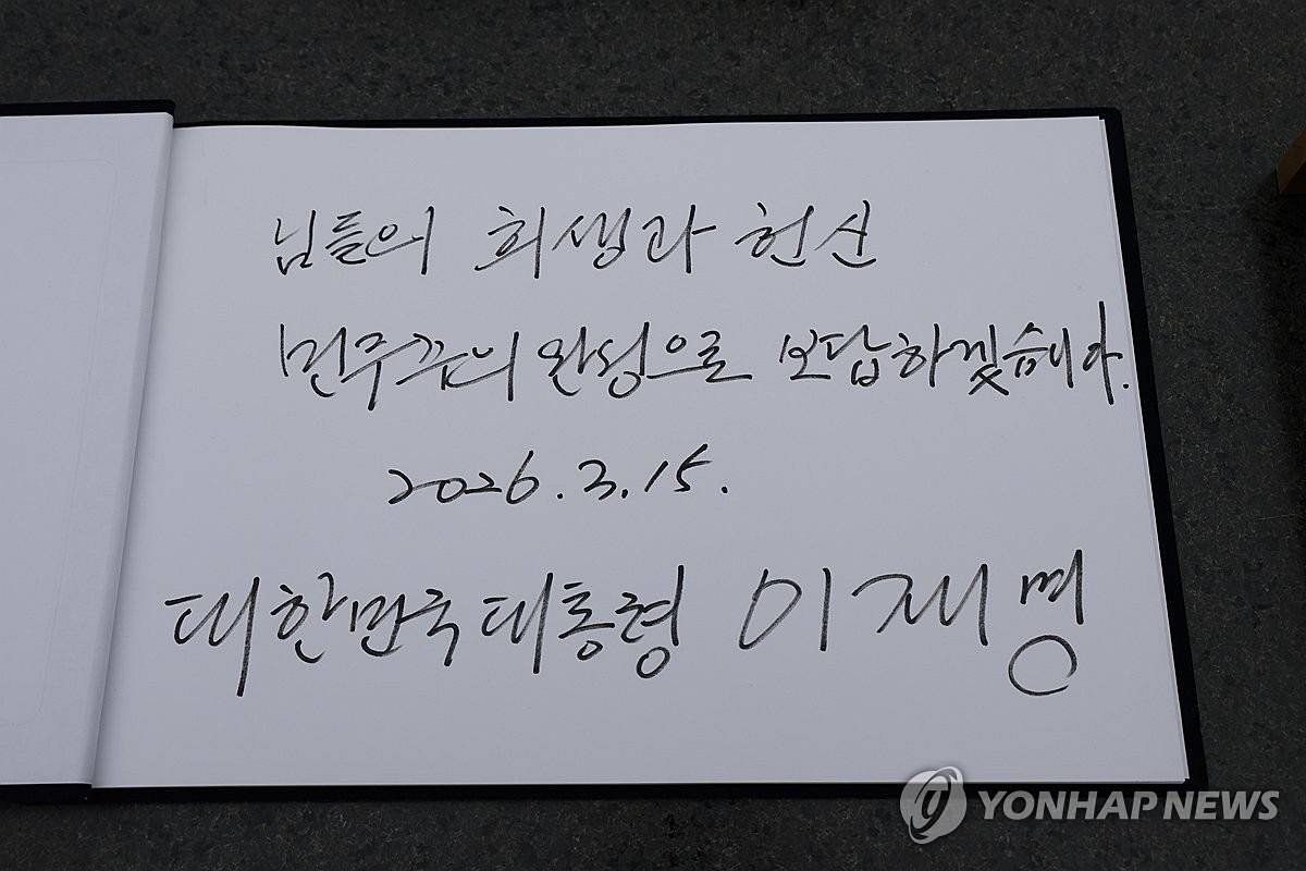 이재명 대통령이 15일 경남 창원시 마산회원구 국립 3·15 민주 묘지 참배를 마친 뒤 작성한 방명록. 이 대통령은 '님들의 희생과 헌신 민주주의 완성으로 보답하겠습니다'라고 적었다 / 청와대통신사진기자단, 연합뉴스