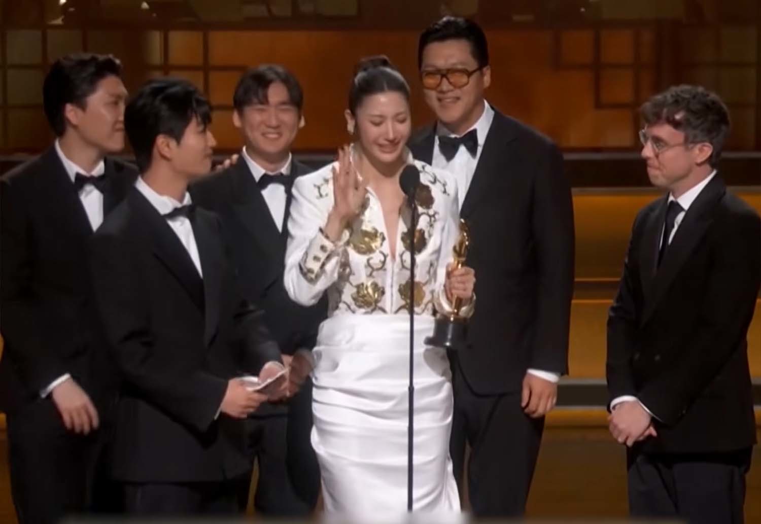 '케이팝 데몬 헌터스' 주제가상 수상팀이 16일(한국시각) 미국 로스앤젤레스 돌비 극장에서 열린 제98회 아카데미 시상식 무대에서 수상 소감을 전하고 있다. 흰색 드레스를 입고 오스카 트로피를 손에 쥔 이재가 눈물을 글썽이며 소감을 밝히는 가운데, 왼편에 선 작곡가들이 준비해 온 소감문을 손에 들고 차례를 기다리고 있다. / TV조선 영상 캡