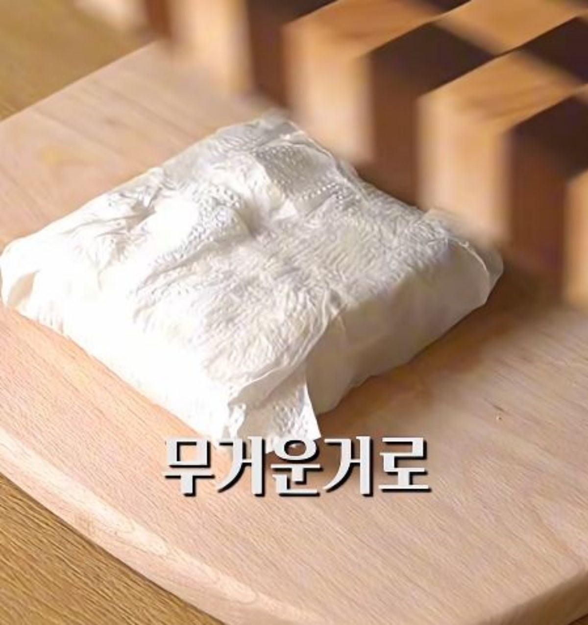 키친타월에 감싼 두부를 무거운 걸로 누르려는 모습. / 유튜브 '요리하는 과장 요과장'