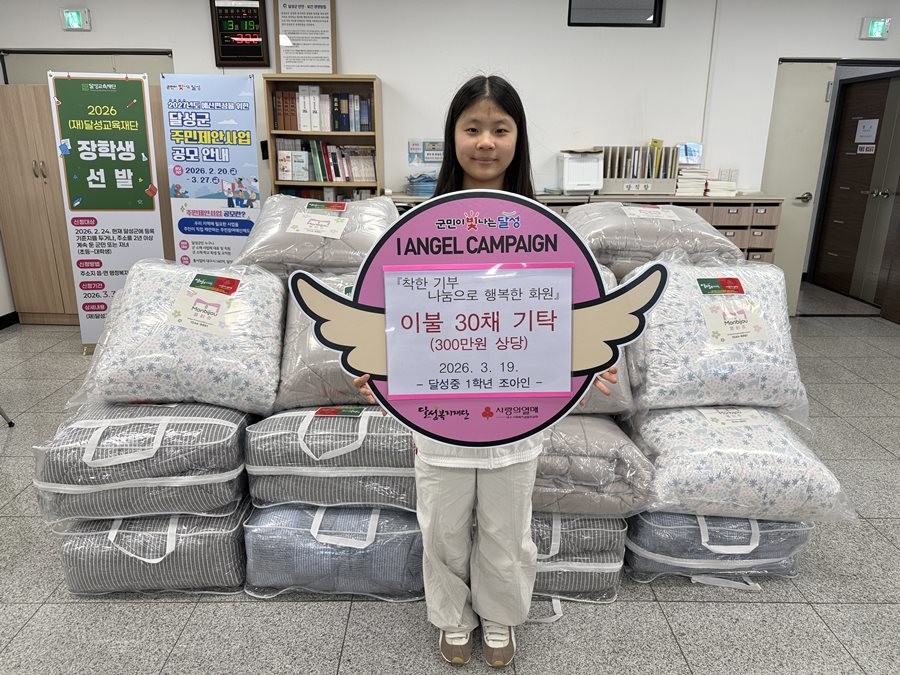 대구 달성중학교에 재학 중인 1학년 조아인 학생이 이불 30채를 달성군 화원읍 행정복지센터에 기탁하고 기념촬영을 하고 있다.  / 대구 달성군 제공