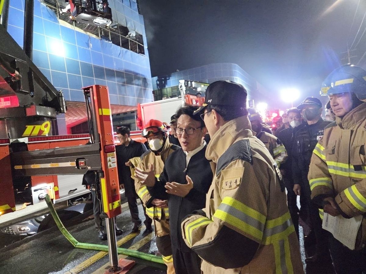 김민석 국무총리가 20일 화재가 발생한 대전 대덕구 문평동 자동차 부품 제조 공장을 찾아 소방 관계자로부터 화재 현황에 대해 보고 받고 있다. 김 총리는 김승룡 소방청장으로부터 10명의 사망자 수습 현황을 보고받은 뒤 안타까움을 표하면서 아직 발견하지 못한 4명의 실종자 수색에도 최선을 다해 달라고 당부했다.    / 국무총리실 제공-뉴스1