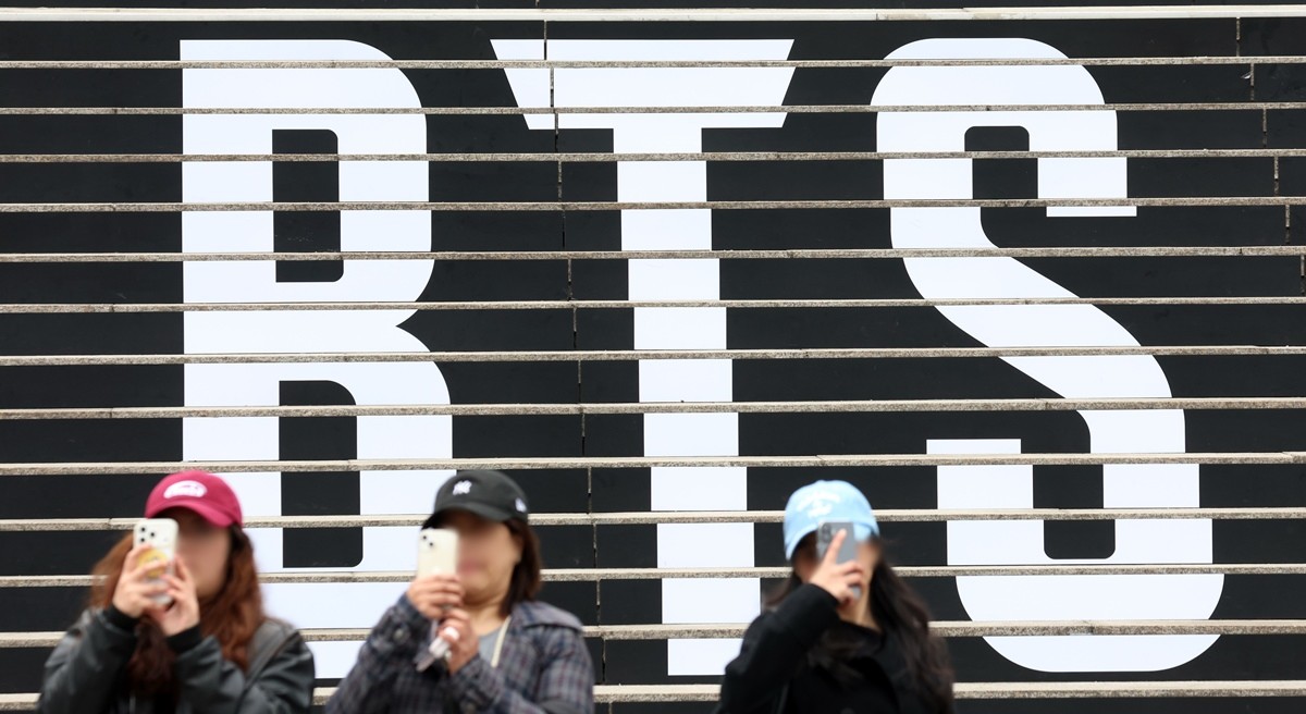 서울 세종문화회관 계단에 마련된 방탄소년단(BTS)의 컴백 라이브 공연 홍보물 앞에서 외국인 관광객이 기념촬영을 하고 있다. 기사 이해를 돕기 위한 자료 사진. BTS가 3년 9개월 만에 컴백하면서 발표한 새 앨범 '아리랑'(ARIRANG)이 발매 당일 400만 장에 육박하는 판매량을 기록해 화제가 됐다. / 뉴스1