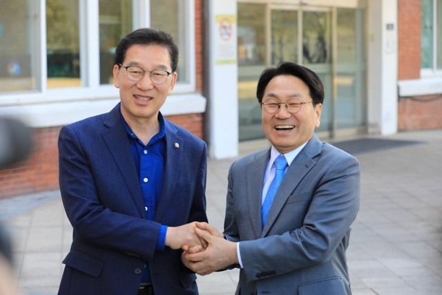 신정훈 후보(왼족)와 강기정 후보가 악수를 하면서 환하게 웃고 있다.