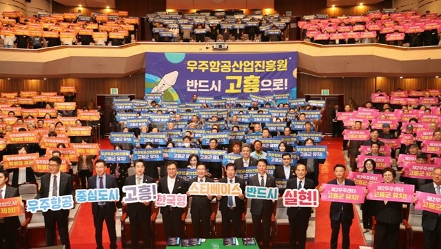 25일 고흥문화회관에서 열린 우주항공복합도시 조성 결의대회 및 포럼에서 참석자들이 우주항공산업진흥원 고흥 유치 의지를 담은 손피켓을 들고 퍼포먼스를 펼치고 있다