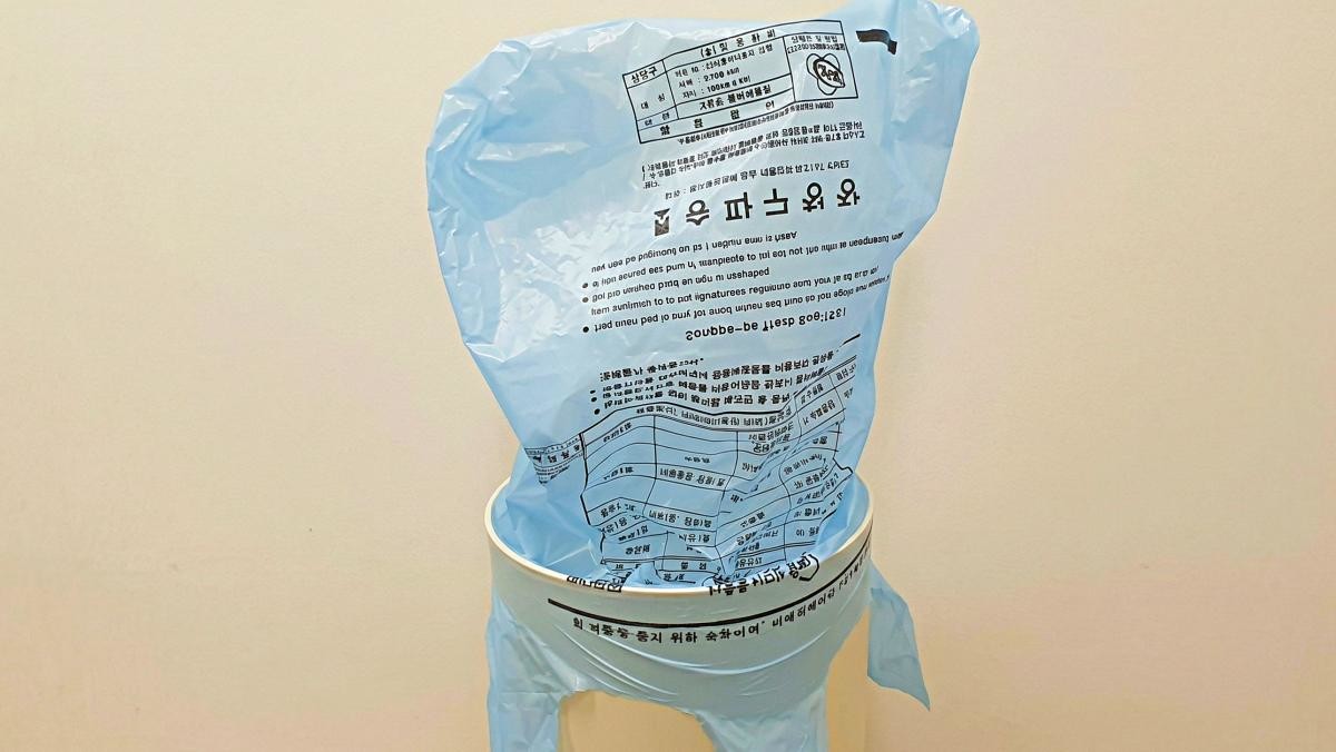 종량제봉투를 쓰레기통에 '모자'처럼 끼우기 꿀팁. 기사 내용 토대로 AI툴 활용해 제작한 자료사진.