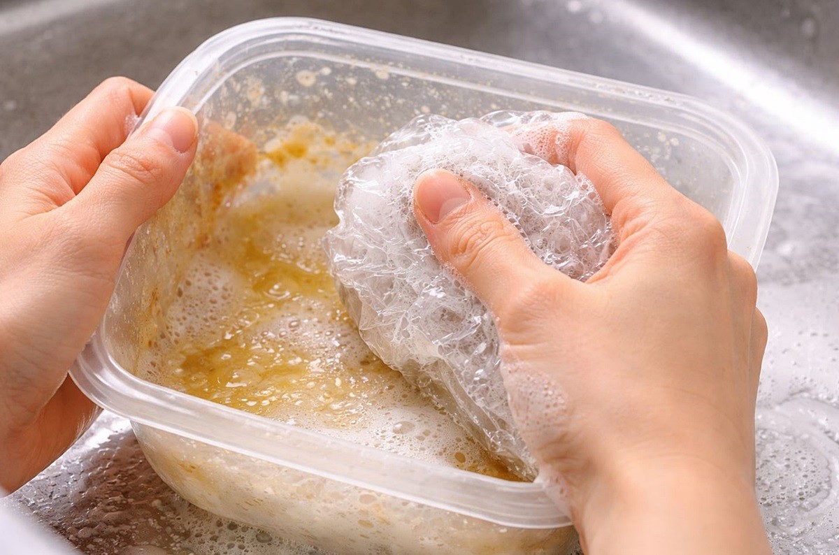 구겨진 비닐봉지에 주방세제를 묻혀 찌든때를 닦아주는 모습. 기사 이해를 돕기 위해 AI를 활용해 제작한 자료 사진입니다. 실제 모습과 다소 차이가 있을 수 있습니다.