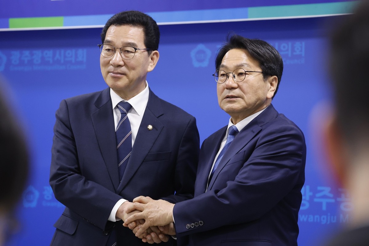 신정훈 후보가 30일 광주시의회에서 더불어민주당 전남광주통합특별시장 강기정 후보와 단일후보로 확정된 후 두손을 맞잡고 있다.  / 뉴스1