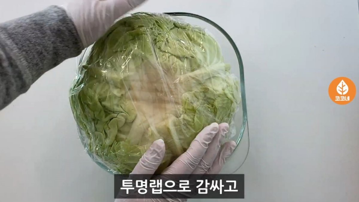 양배추에 따뜻한 물을 넣은 후 온기가 빠지지 않도록 랩으로 감싼 모습. / 유튜브 '코코네'
