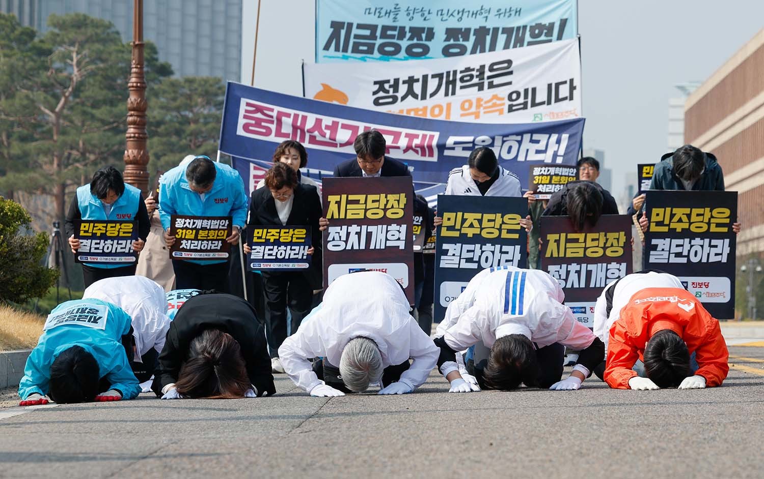 신지혜 기본소득당 최고위원(앞줄 왼쪽부터), 손솔 진보당 의원, 서왕진 조국혁신당 원내대표, 조국 대표, 한창민 사회민주당 대표를 비롯한 진보4당 의원 및 당직자들이 26일 서울 여의도 국회 앞에서 정치개혁을 촉구하며 삼보일배를 하고 있다. / 뉴스1