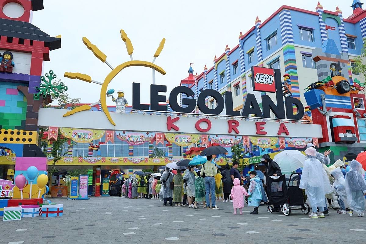 강원 춘천 레고랜드 정문 앞에 우산과 우비를 쓴 어린이들이 부모와 함께 입장을 하기 위해 기다리고 있다 / 레고랜드 제공, 뉴스1
