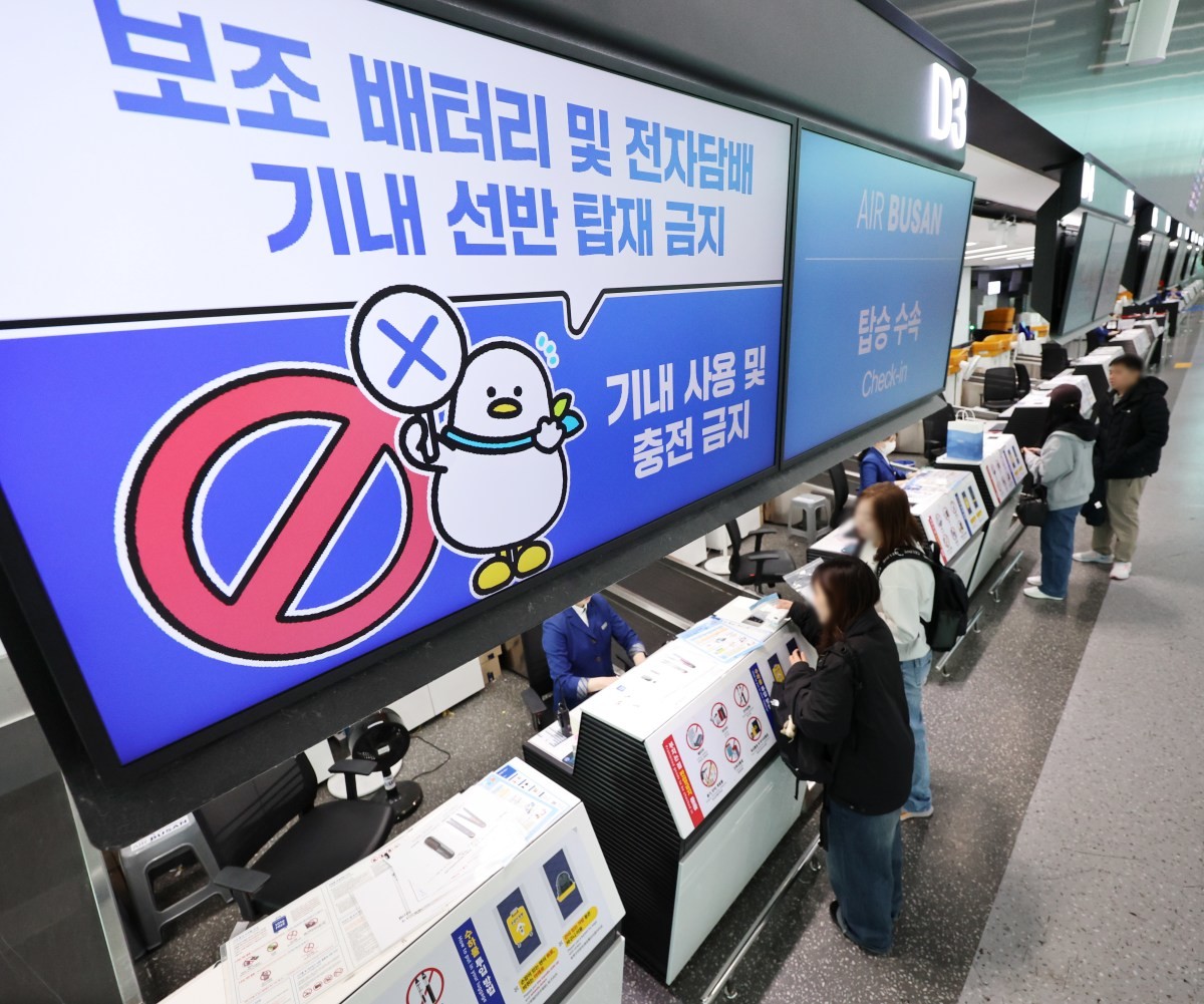 부산 강서구 김해국제공항 에어부산 탑승 수속 카운터에 보조배터리 기내 사용 및 충전 금지 안내문이 뜨고 있다. / 연합뉴스