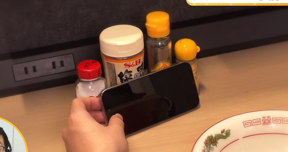 조미료통 위에 스마트폰을 올려둔 채 식사하는 모습. / FNNプライムオンライン 유튜브 캡처