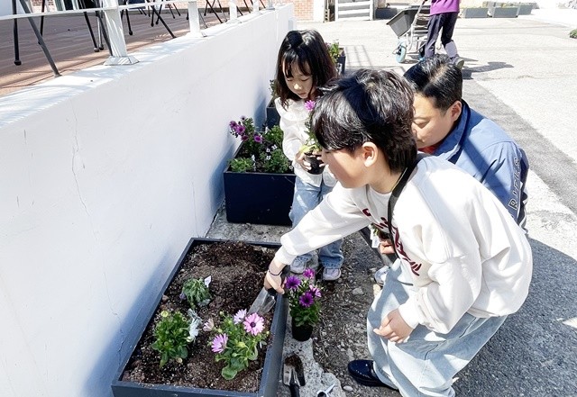참가자들이 직접 흙을 만지며 꽃모종을 심는 한편, 버려지는 빈 생수통을 재활용한 '나만의 업사이클링 화분'을 만들며 환경 보호의 의미까지 되새겼다.  / 장흥군