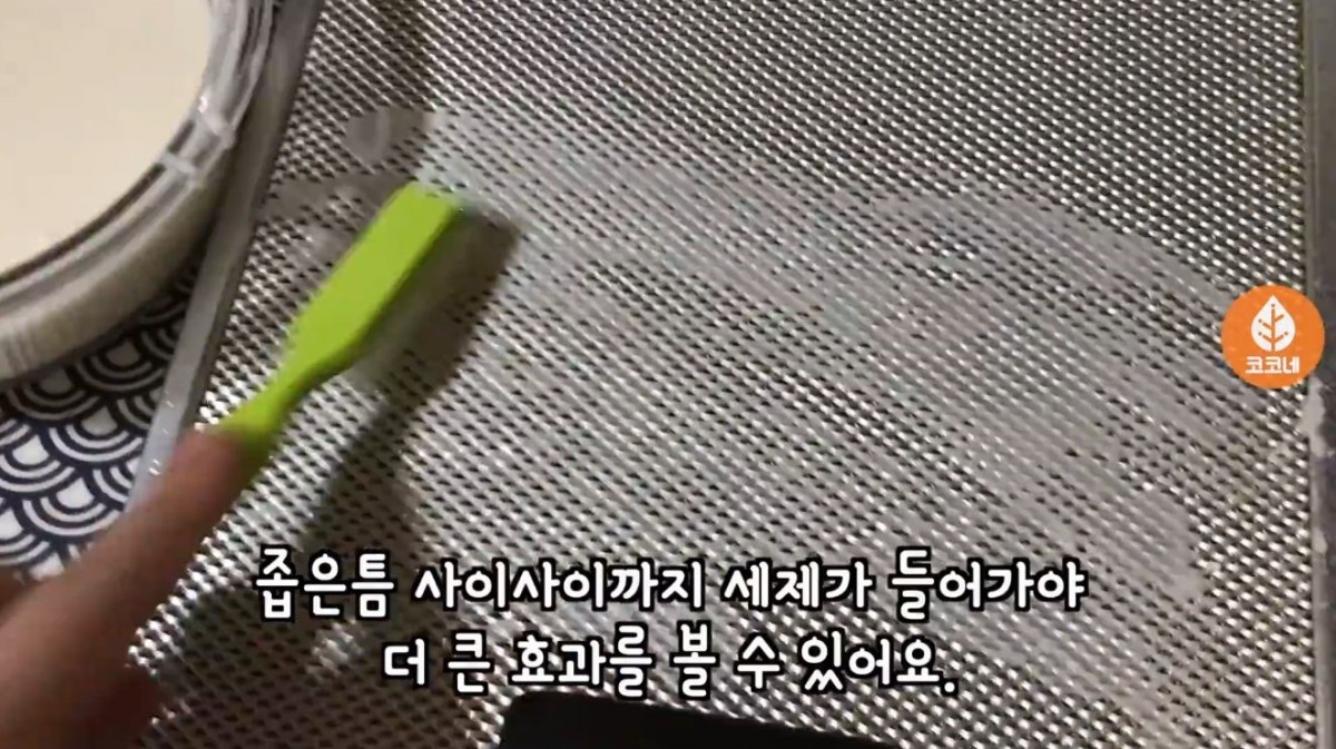 밀가루와 치킨 무 국물을 섞은 세제를 주방 후드에 꼼꼼히 도포하는 모습. / 유튜브 '코코네'