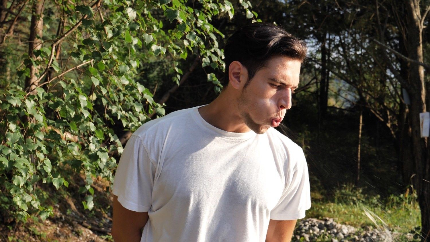 야외 공간에서 한 남성이 고개를 돌린 채 침을 뱉고 있는 모습이다. / 셔터스톡