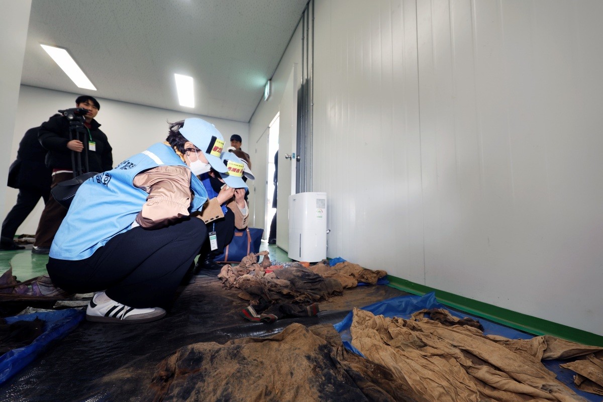 전남 무안군 무안국제공항에서 여객기 참사 유가족들이 179명의 희생자들의 유류품이 보관된 장소에 주저 앉아 눈물 흘리고 있다 / 뉴스1