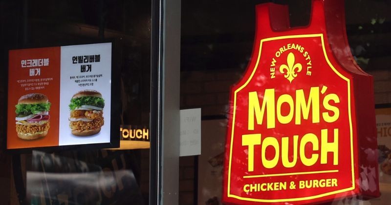 '맘스터치(Mom's Touch)'의 강렬한 붉은색 간판이 선명하게 빛나고 있다 / 뉴스 1