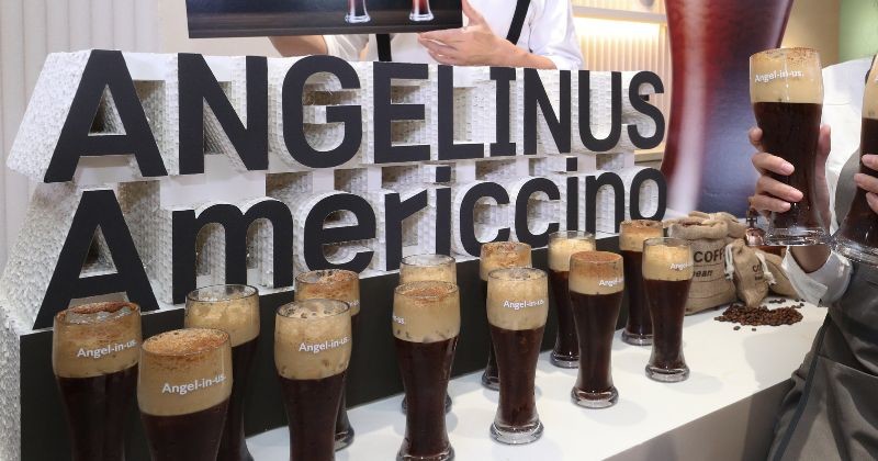 엔제리너스(Angel-in-us) 커피의 홍보 행사장에서 대표 메뉴인 '아메리치노(Americcino)'가 화려하게 전시되어 있다 / 뉴스 1