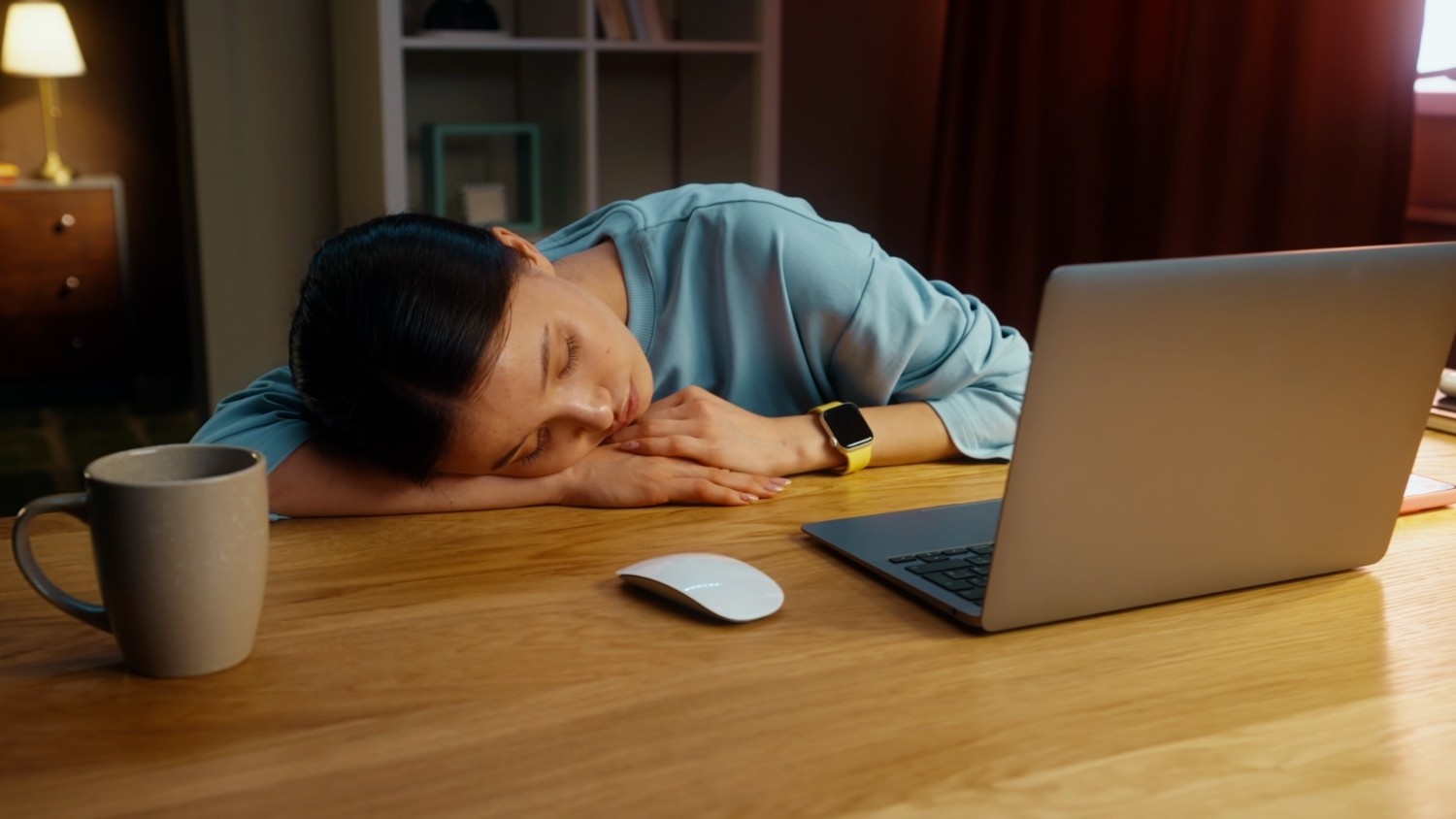 노트북이 놓인 책상 앞에서 한 여성이 피곤한 듯 엎드려 잠들어 있는 모습이다. / 셔터스톡