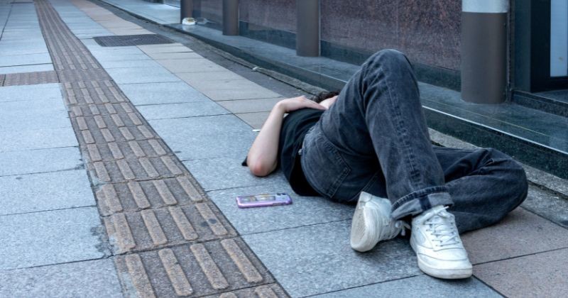 술에 취해 새벽에 도로에서 자고 있는 남자 / 셔터스톡