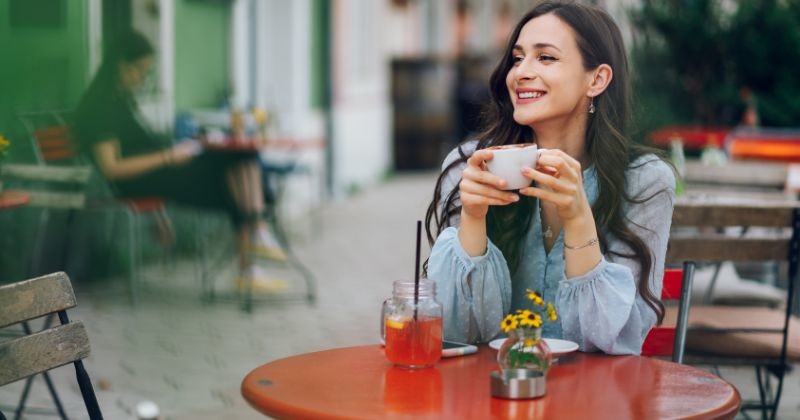 야외에 있는 카페에 앉아 웃고 있는 아름다운 젊은 여자. 카페 밖의 낭만적인 정원에서 에스프레소 커피를 마시는 백인 여성의 초상화 / 셔터스톡