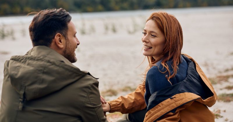 가을날 자연 속에서 소통하는 편안한 남자와 여자 / 셔터스톡