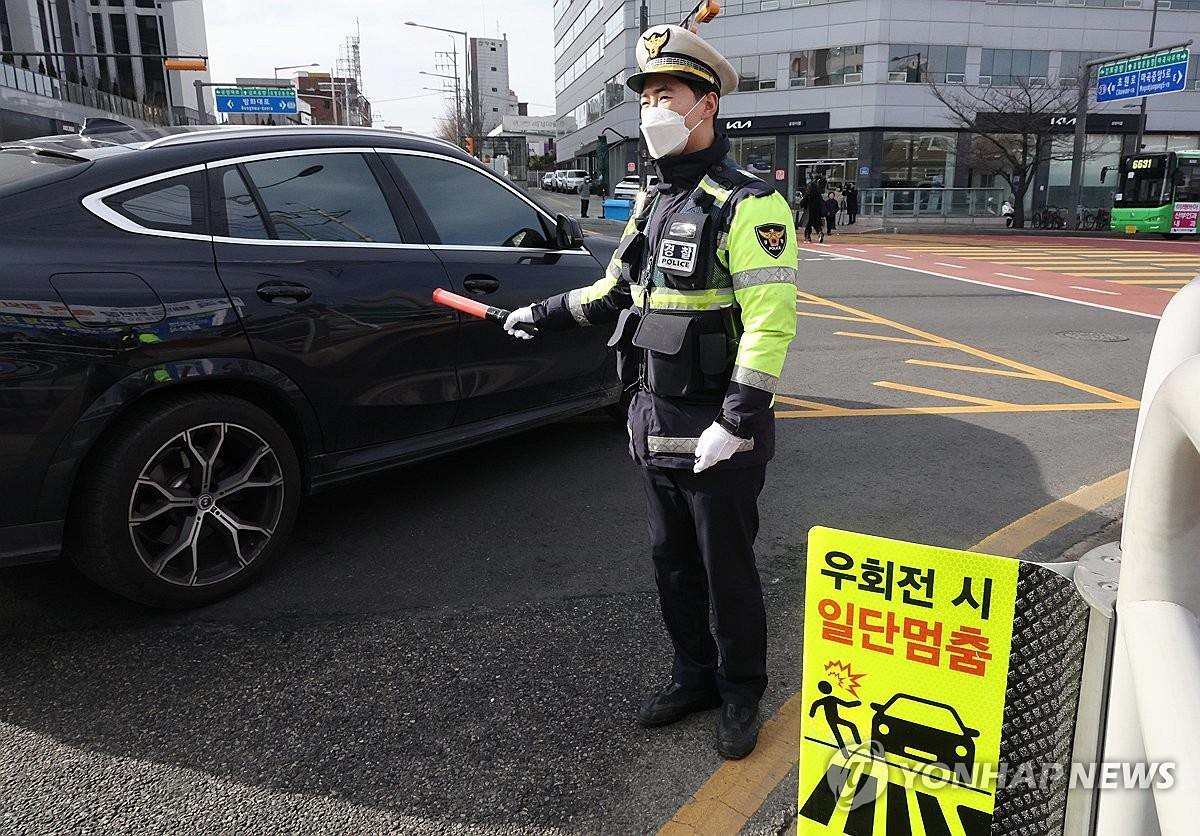 우회전 일시 정지 계도 및 단속 활동을 벌이는 경찰 / 연합뉴스